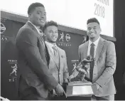  ?? RALPH RUSSO/AP ?? Heisman Trophy finalists, from left, Dwayne Haskins, from Ohio State, Kyler Murray, of Oklahoma, and Tua Tagovailoa, from Alabama, pose with the Heisman Trophy at the New York Stock Exchange, Friday.