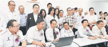  ??  ?? Wong (seated third left) being briefed on the UPP Padungan branch website.