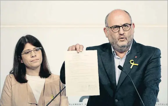  ?? ANDREU DALMAU / EFE ?? El portavoz de JxCat, Eduard Pujol, muestra, junto a Gemma Geis, la acreditaci­ón de Carles Puigdemont como diputado del Parlament