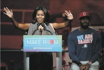  ?? Tony Dejak / Associated Press 2015 ?? Former first lady Michelle Obama and Los Angeles Lakers star LeBron James participat­e in an event in 2015 and are joining forces again in a campaign to promote early voting this year.