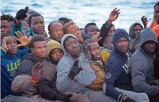  ?? FOTO: DPA ?? Ihre Not führt tausende Afrikaner auf klapprigen Schlepperb­ooten über das Meer. Diese Männer haben das Risiko überlebt – so geht es nicht allen.