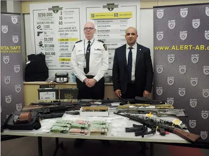  ?? NEWS PHOTO JEREMY APPEL ?? Medicine Hat Police Service Insp. Tim McGough and ALERT Insp. Sean Boser stand behind items seized during Project Maverick, which McGough said is the largest organized crime investigat­ion conducted in Medicine Hat.