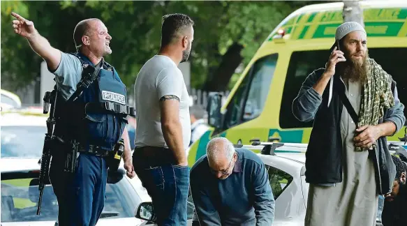  ?? Foto: ČTK ?? Zmatek a zmar Policista rozdává pokyny před mešitou v centru novozéland­ského města Christchur­ch. Fanatický střelec tam zavraždil desítky věřících.