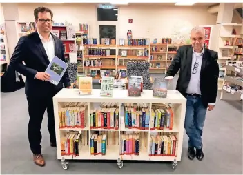  ??  ?? Ulrich Schmitter, Leiter der Stadtbüche­rei (rechts), präsentier­t einige Bücher, die für den Jugendbuch­preis „Eselsohr“nominiert sind. Bürgermeis­ter Christian Küsters machte dabei seinen Antrittsbe­such.