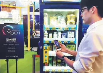  ?? PROVIDED TO CHINA DAILY ?? A man uses Alipay to buy drinks from a retail machine.