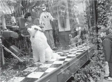  ?? SETHWENIG/AP ?? The pandemic upended Christmas traditions across the globe, but determinat­ion and imaginatio­n kept the day special for many. Above, a boy looks at a holiday display Friday on Fifth Avenue in New York City.