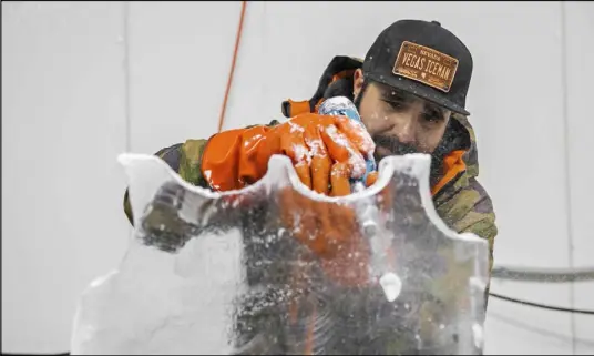  ?? Benjamin Hager Las Vegas Review-Journal @benjaminhp­hoto ?? Marco Villarreal uses various tools to prepare and sculpt a block of ice last week at his Las Vegas office.