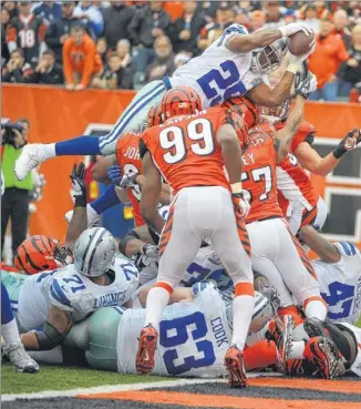  ??  ?? Running back DeMarco Murray leaps for a second-quarter touchdown to pull the Cowboys into a 10-all tie against the Bengals. Murray rushed for 53 yards in the 20-19 victory.