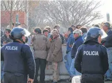  ??  ?? DEL OTRO lado. El alambrado dividía; la policía custodiaba.