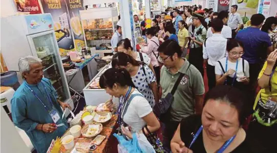  ?? [FOTO SHAHRUL M ZAIN/BH] ?? Pengunjung mendapatka­n penerangan daripada usahawan Malaysia di Malaysia pavilion sempena CAEXPO di Nanning.