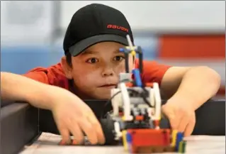  ?? BARRY GRAY, THE HAMILTON SPECTATOR ?? Quinten Shannon from the St. Joachim Robotics team eyes a robot made from Lego bricks at Cardinal Newman Secondary School for the second annual Hamilton First Lego League qualifier Saturday.