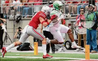  ?? Gaelen Morse / Getty Images ?? C.J. Verdell runs for one of his three touchdowns on the afternoon in a 35-28 upset of Ohio State in Columbus.