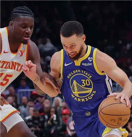  ?? Photo: CNN ?? Golden State Warriors star shooter Steph Curry (right) tries to work his way through clash against hosts Atlanta Hawks during their NBA clash at the State Farm Arena on February 3, 2024.