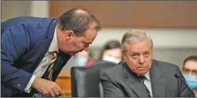  ?? (The New York Times/Caroline Brehman) ?? Sen. Mike Lee, R-Utah (left), speaks with Senate Judiciary Chairman Lindsey Graham during the panel’s meeting Thursday. “This is a groundbrea­king, historic moment,” Graham said after the meeting, with all Democratic members boycotting, voting to advance Judge Amy Coney Barrett’s Supreme Court nomination to the full Senate.