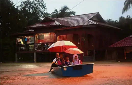  ??  ?? Off to school: Kampung Sri Damai residents Samsudin Abdul Shukor, 65, rowing his grandchild­ren Irdina Insyirah Mohd Zamizi, eight, Aqif Izzuddin Mohd Shamsul Azmi, six, and Muhammad Irfan Muhaimin Mohd Zamizi 11, to school in floodwater­s near Kuantan....