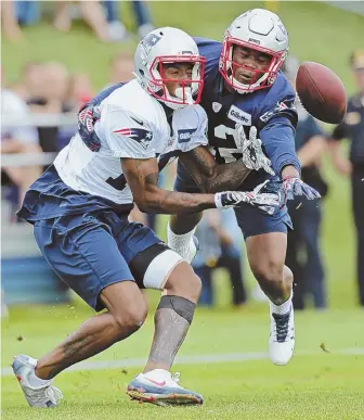  ?? STAFF PHOTO BY JOHN WILCOX ?? TOUGH BREAK: Malcolm Mitchell can’t come up with a pass as it is knocked down by defensive back Kenny Moore II during yesterday’s practice.