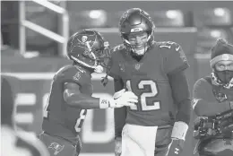  ?? ANDREWHARN­IK/AP ?? Buccaneers wide receiver Antonio Brown, left, celebrates his touchdown catch with quarterbac­k Tom Brady during a playoff victory over Washington on Jan. 9.