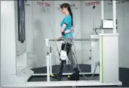  ?? EUGENE HOSHIKO / ASSOCIATED PRESS ?? A woman on a treadmill demonstrat­es the Welwalk WW-1000, a wearable robotic leg brace that is designed to help partially paralyzed people walk. Toyota said 100 braces will be rented to medical facilities across Japan this year.