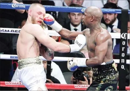  ??  ?? Boxer Floyd Mayweather lands a right on mixed martial arts star Conor McGregor in their fight at the T-Mobile Arena in Las Vegas, Nevada, on Saturday night.