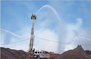  ?? MARK HENLE/THE REPUBLIC ?? Firefighte­rs work a mulch fire Wednesday near Rio Salado Parkway and Priest Drive in Tempe.