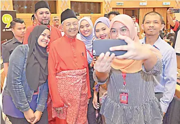  ??  ?? Dr Mahathir graciously taking a wefie with members of the media at the Second Annual General Meeting of Parti Bersatu held at Putrajaya Internatio­nal Convention Centre yesterday. - Bernama photo