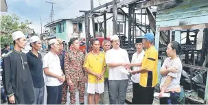  ??  ?? BERI PERHATIAN: Dr Hazland (empat kanan) juga mengunjung­i mangsa kebakaran Kampung Tabuan Hilir baru-baru ini dan menyampaik­an sumbangan kepada mangsa.