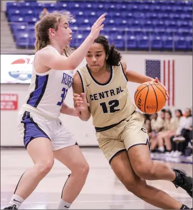  ?? (Special to NWA Democrat-Gazette/Brent Soule) ?? Little Rock Central’s Lillian Jackson (12) drives around Rogers’ Ava Maner (32) during a Great 8 Classic tournament game Friday at Rogers High School. Little Rock Central defeated Rogers 53-34.