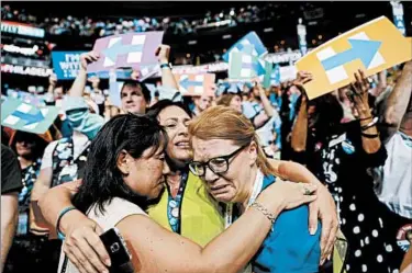  ?? JOHN LOCHER/ASSOCIATED PRESS ?? Convention attendees share an emotional moment as Hillary Clinton becomes the Democratic Party’s nominee.