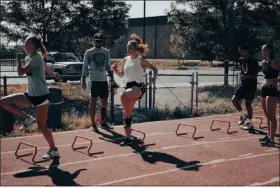  ?? PHOTO BY CARMI EDWARDS — PROVIDED BY EVAN GERISH ?? Evan Gerish, second from left, works with athletes during a recent training session at Hurdle Tech, an outfit Gerish started in order to help local hurdlers get more expansive instructio­n.