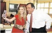  ?? Bill Denver / Associated Press ?? New Jersey Gov. Chris Christie, taking a moment to snap a selfie with a supporter Tuesday, will be excluded from the GOP’s main debate next week.