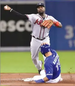  ?? The Canadian Press ?? Atlanta Braves’ second baseman Brandon Phillips forces out Toronto Blue Jay Jose Bautista while turning a double play during interleagu­e baseball action in Toronto on Tuesday.