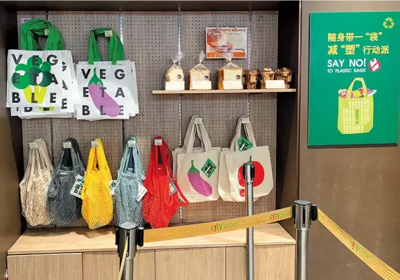  ??  ?? Supermarke­ts across Shanghai have stopped offering plastic bags free starting from January 1. They are now selling reusable bags as an alternativ­e for shoppers who haven’t brought their own grocery bags. — Li Anlan