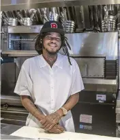  ?? PEDRO PORTAL pportal@miamiheral­d.com ?? Brian Aikens, a longtime Overtown resident, gets ready to start his shift as a line cook at the Red Rooster.