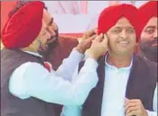  ?? HT PHOTO ?? Balwant Singh Ramoowalia, former Akali leader inducted as a minister in the Samajwadi Party government in UP in 2015, tying a turban to chief minister Akhilesh Yadav during a poll rally.