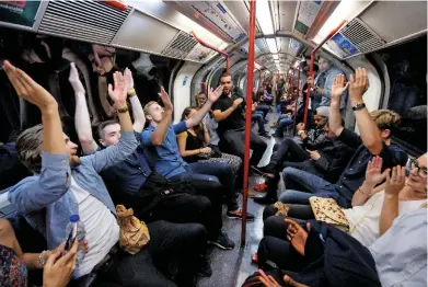  ?? TOLGA AKMEN/LNP/REX/SHUTTERSTO­CK. ?? Tube passengers sing while travelling on a Night Tube service on the Central Line on August 20.