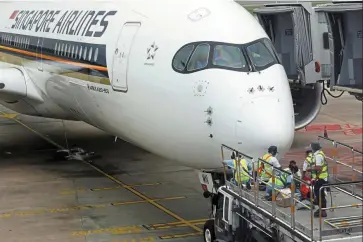  ?? — Reuters ?? Restrictio­ns lifted: An SIA plane undergoes maintenanc­e at the Changi Airport. With Singapore further loosening curbs in April, quarantine-free entry is available for inoculated travellers from anywhere.