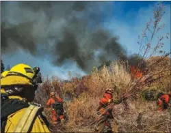  ?? Los Angeles Times/tns ?? Inmate firefighte­rs clear brush as they work to slow down the spread of the Maria Fire on the Santa Clara river bed, in Santa Paula on Nov. 1.