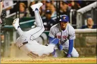  ?? Alex Brandon / Associated Press ?? The Mets’ Eduardo Escobar rolls over after scoring on a sacrifice fly with Brandon Nimmo at right, during the sixth inning Tuesday against the Nationals.