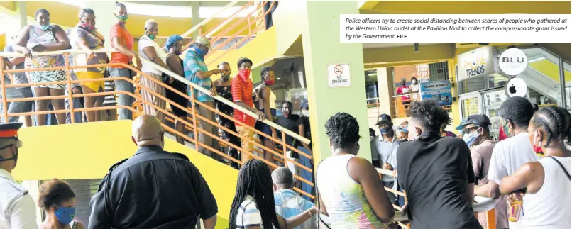  ?? FILE ?? Police officers try to create social distancing between scores of people who gathered at the Western Union outlet at the Pavilion Mall to collect the compassion­ate grant issued by the Government.