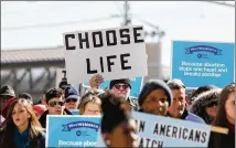  ?? REANN HUBER / REANN.HUBER@AJC.COM ?? A man holds up a “Choose Life” sign during the Georgia March for Life in Downtown Atlanta on Friday. More than 200 people marched through the streets.