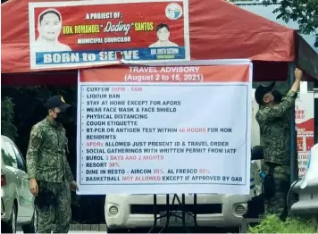  ?? Chris Navarro ?? QUARANTINE CHECK POINT
Pampanga policemen put up a travel advisory issued by Governor Dennis Pineda in line with the additional safety protocols under the MGCQ.