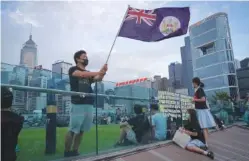  ?? AP PHOTO/VINCENT YU ?? A protester waves the Hong Kong British colony flag during continuing pro-democracy rallies on Sept. 3, 2019, in Tamar Park, Hong Kong.