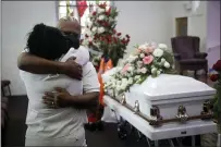  ?? AP PHOTO/MARCIO JOSE SANCHEZ, FILE ?? Darryl Hutchinson, facing camera, is hugged by a relative during a funeral service for Lydia Nunez, who was Hutchinson’s cousin at the Metropolit­an Baptist Church in Los Angeles. Nunez died from COVID-19.