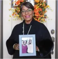  ?? STAFF PHOTO BY OLIVIA ROSS ?? Joy Hudson holds a photo of John “Johnny” Wesley Henry outside her home on Monday. Henry died from COVID-19.