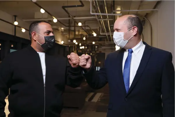  ?? (Courtesy Ilan Ben Harosh) ?? EXCHANGING FIST bumps with Yamina head Naftali Bennett.
ILAN BEN HAROSH, an early Shulman member, says Kara acted aggressive­ly toward other members of the group.