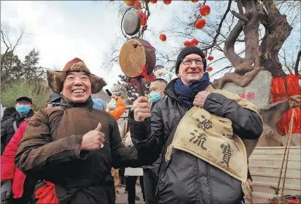  ?? DU JIANPO / FOR CHINA DAILY ?? A foreign visitor dresses up as a vendor at a temple fair in suburban Beijing in January.
