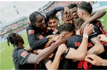  ?? FOTO: ROLF VENNENBERN­D/DPA ?? Leverkusen­s Florian Wirtz (unten) wird nach seinem Tor zum 3:0 von den Teamgefähr­ten umjubelt. Der Nationalsp­ieler legte noch zwei Treffer zum 5:0-Erfolg gegen Bremen nach.