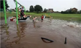  ??  ?? Children playing in a flooded park in Newcastle-under-Lyme. Photograph: Carl Recine/ Reuters