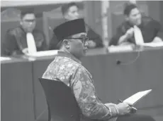  ?? FEDRIK TARIGAN/JAWA POS ?? MENYIMAK: Mantan Menpora Imam Nahrawi mendengark­an pembacaan dakwaan oleh jaksa KPK di Pengadilan Tipikor, Jakarta, Jumat (14/2).