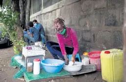  ?? Hilina Abebe, © The New York Times Co. ?? Tsige Alelign, 24, who earns a living making coffee in Addis Ababa, Ethiopia, washes dishes in a plastic bin on Sept. 2. A limited supply of food and other factors have pushed prices higher, just as vast numbers of people have seen their incomes fall.